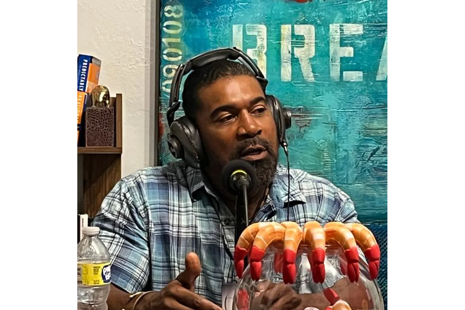 a person wearing headphones and holding a box of hot dogs