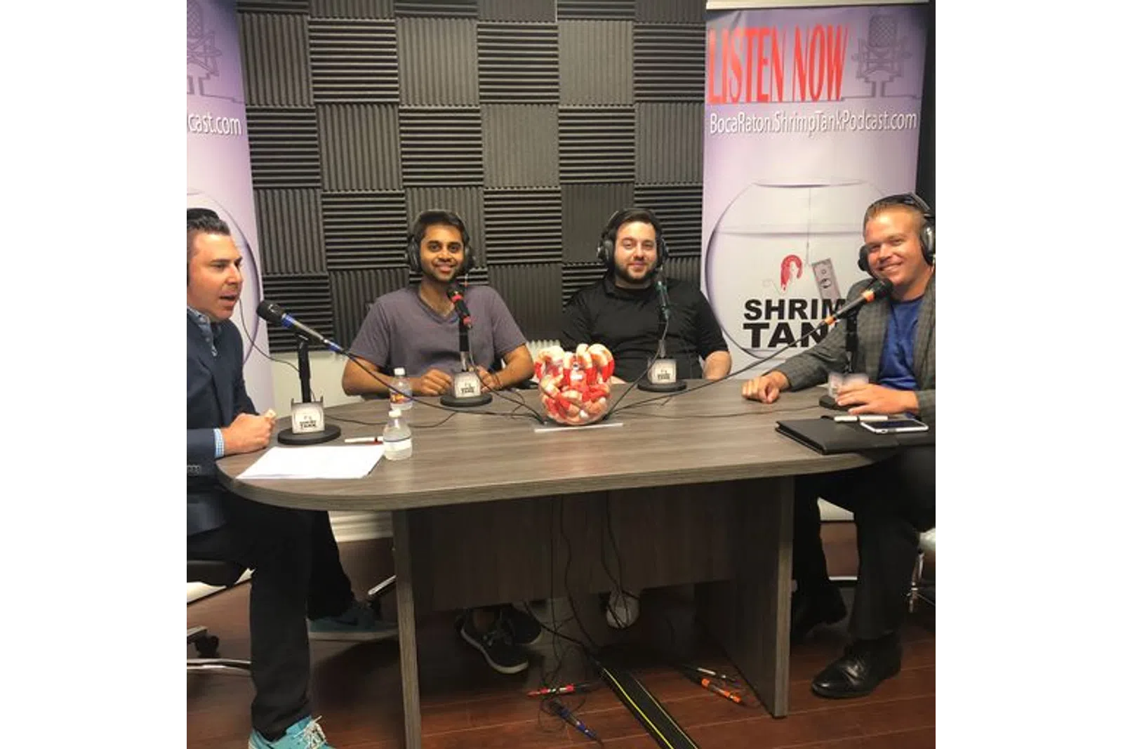 a group of men sitting at a table with a microphone