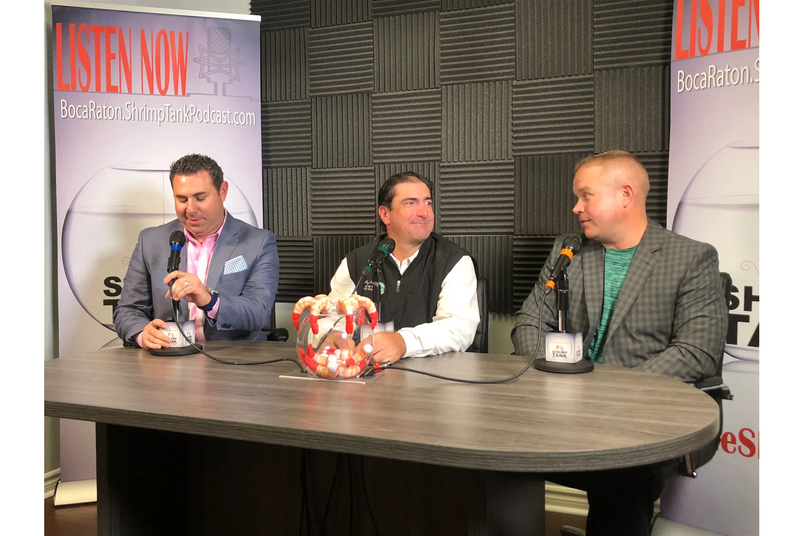 a group of men sitting at a table with microphones