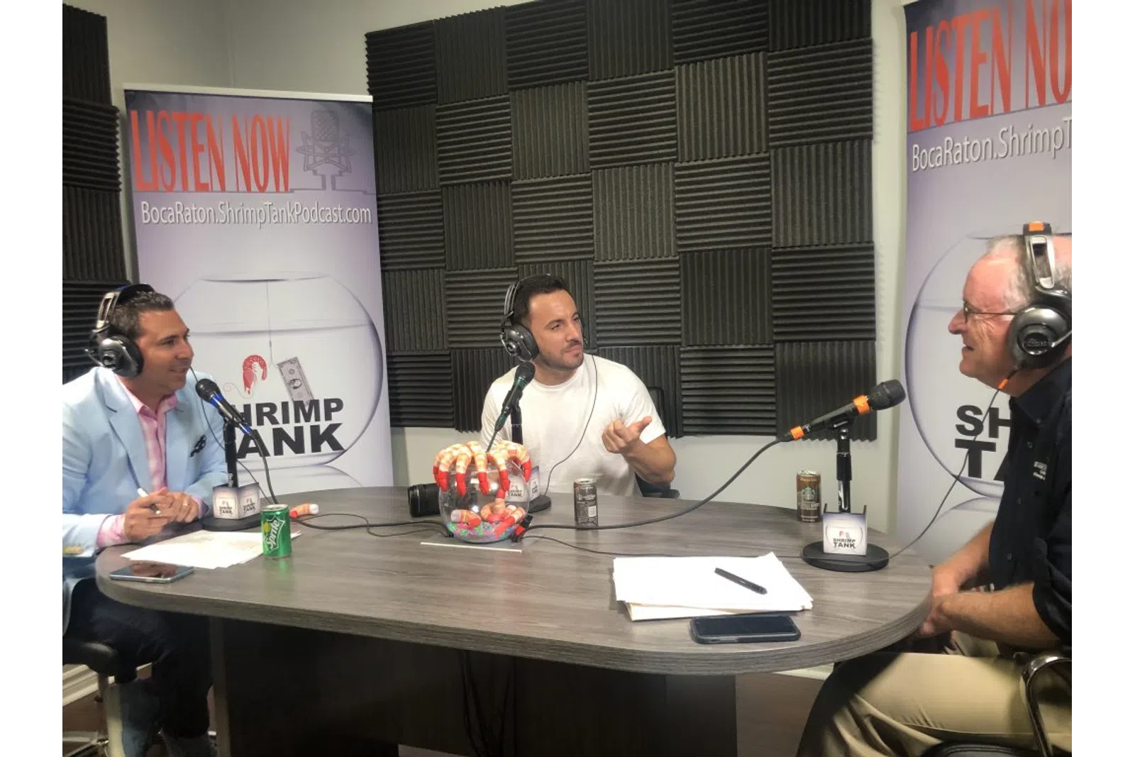 a group of people sitting at a table with microphones