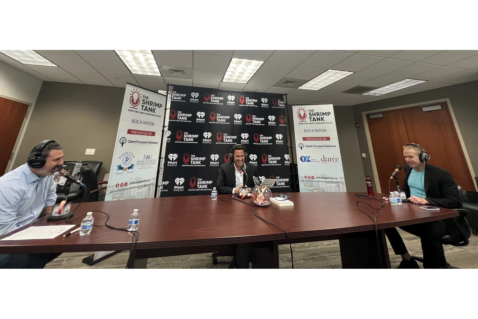 a group of people sitting at a table with microphones