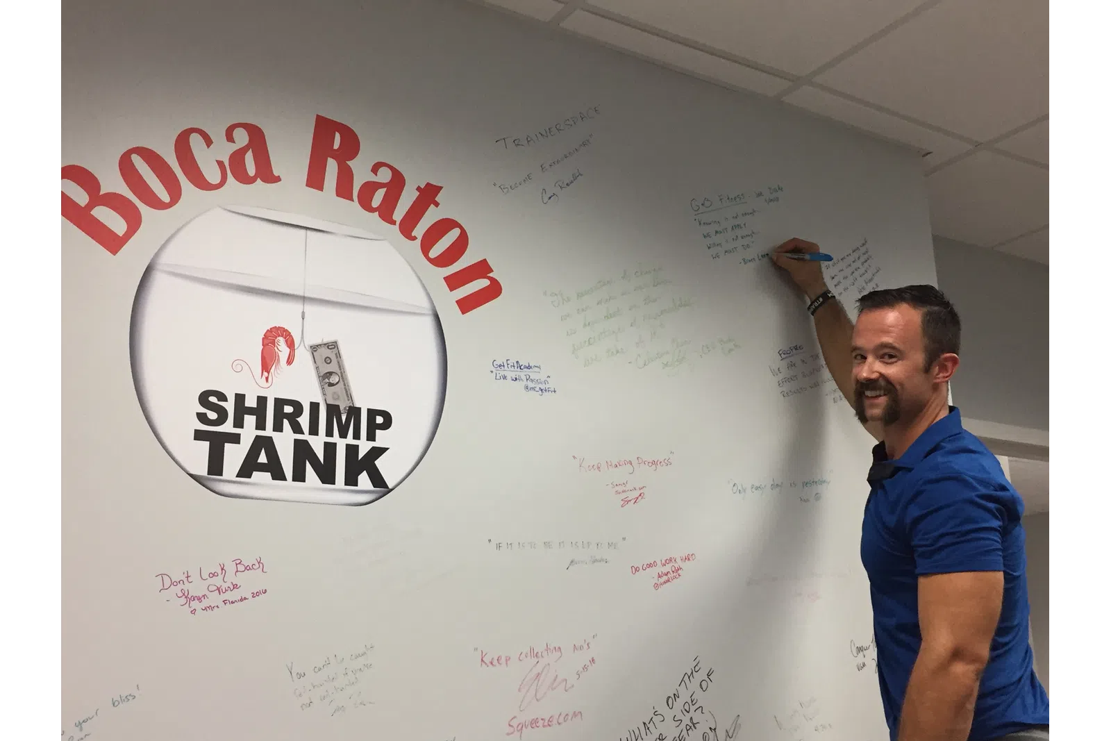a man standing next to a white board with writing on it