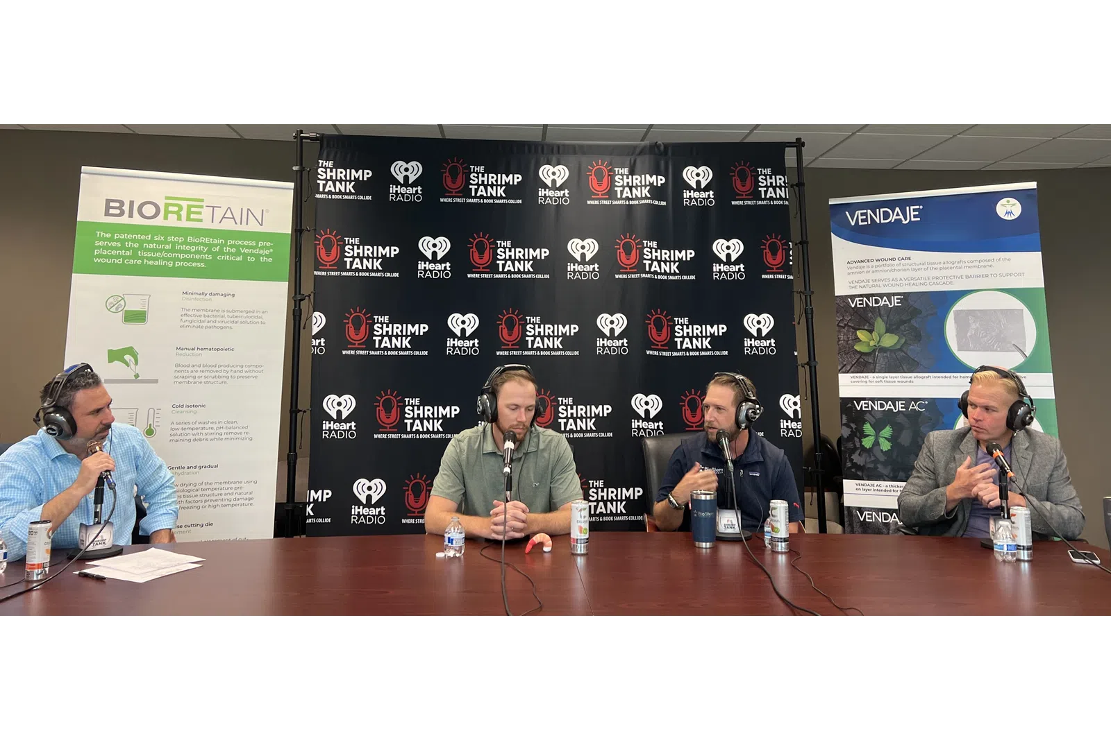 a group of people sitting at a table with microphones