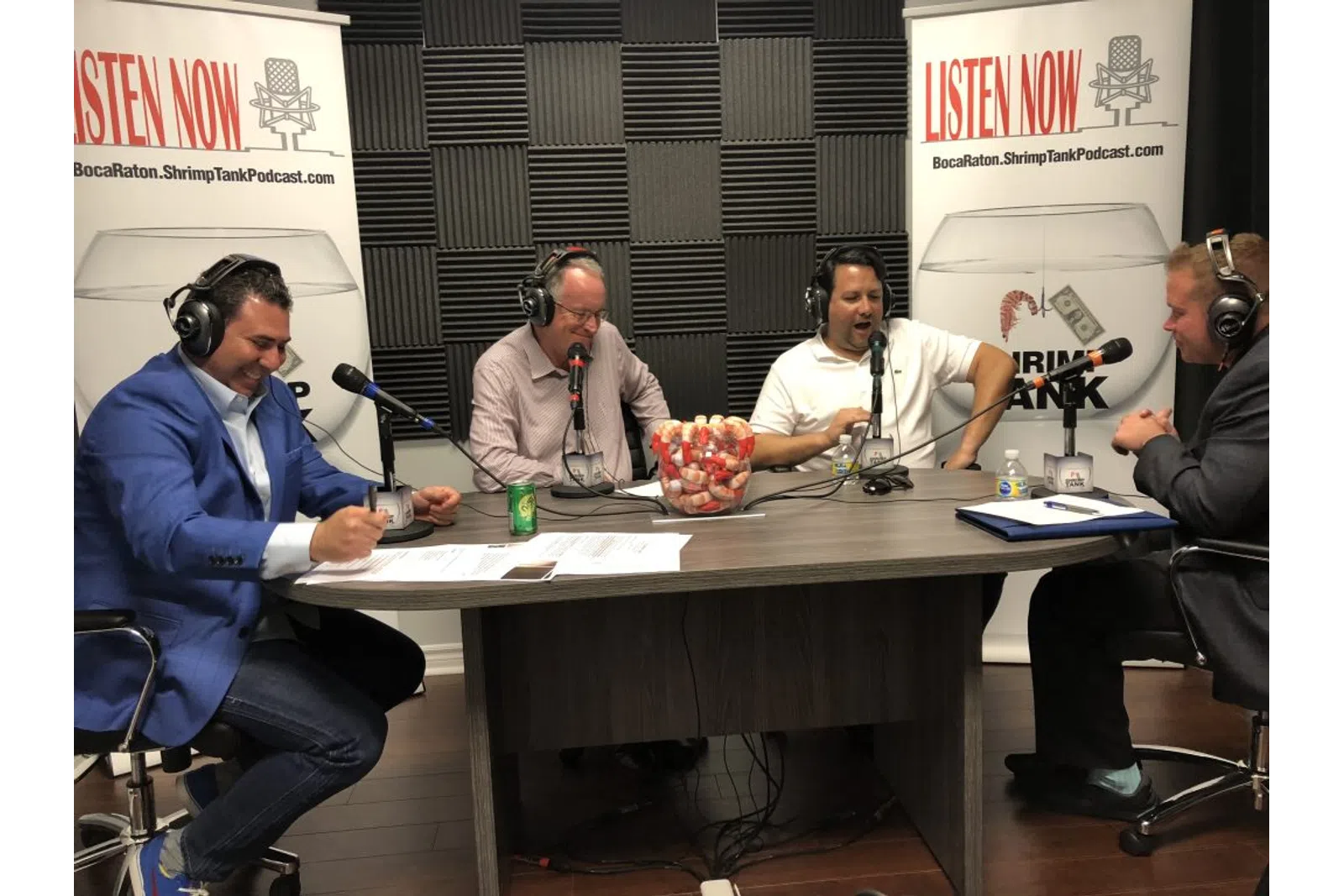 a group of people sitting at a table with microphones