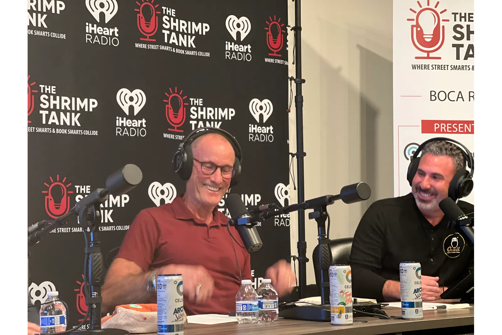 a couple of men sitting at a table with microphones