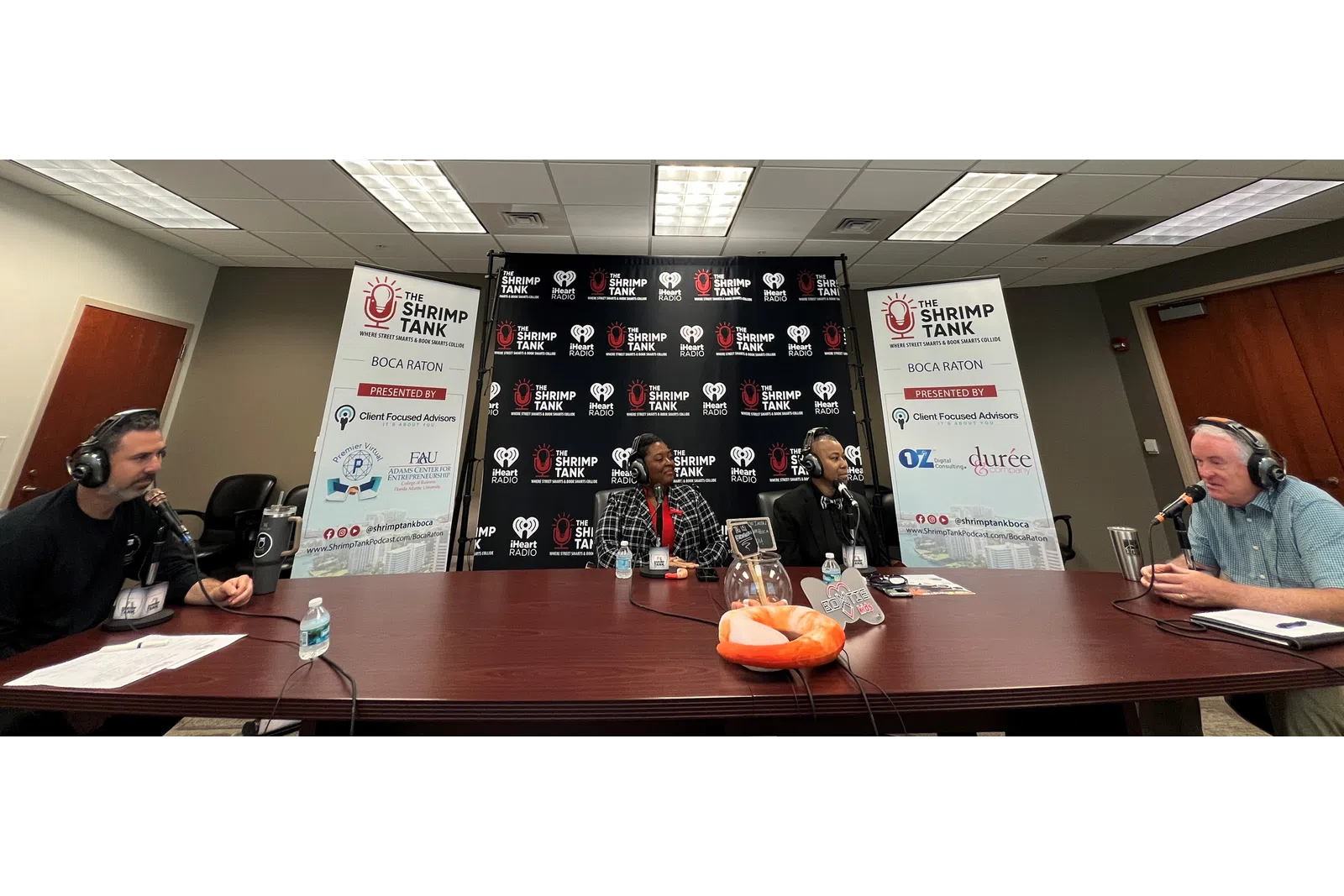 a group of people sitting at a table with microphones