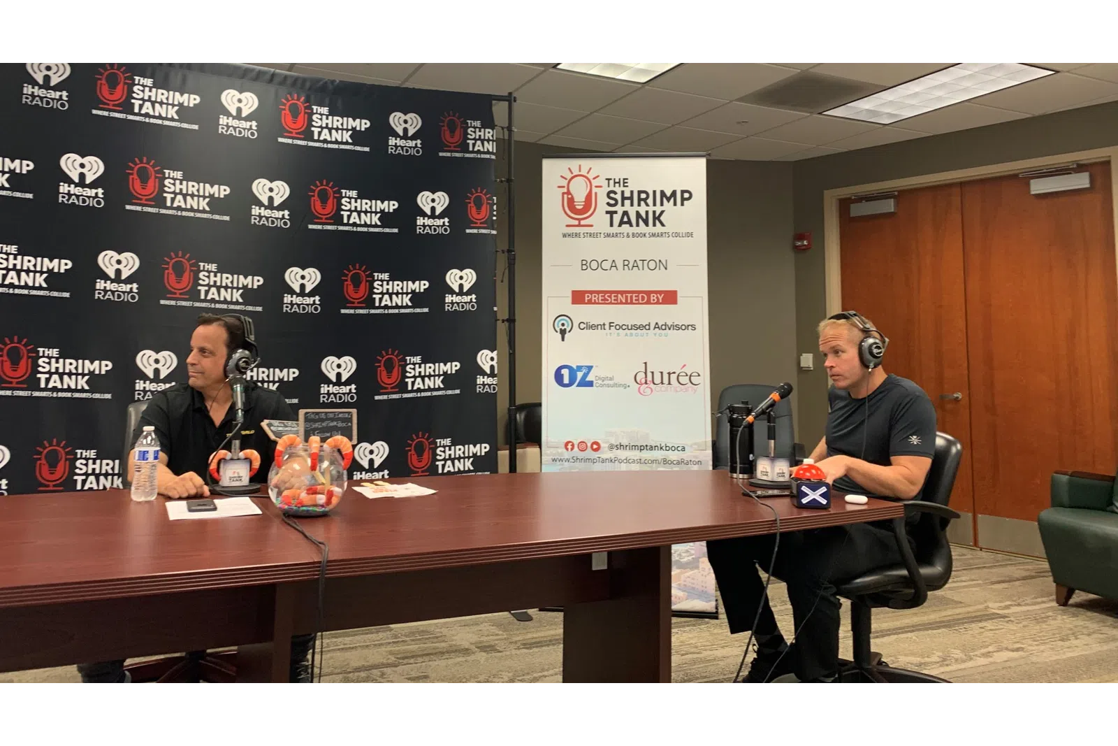 a couple of men sitting at a table with headphones on