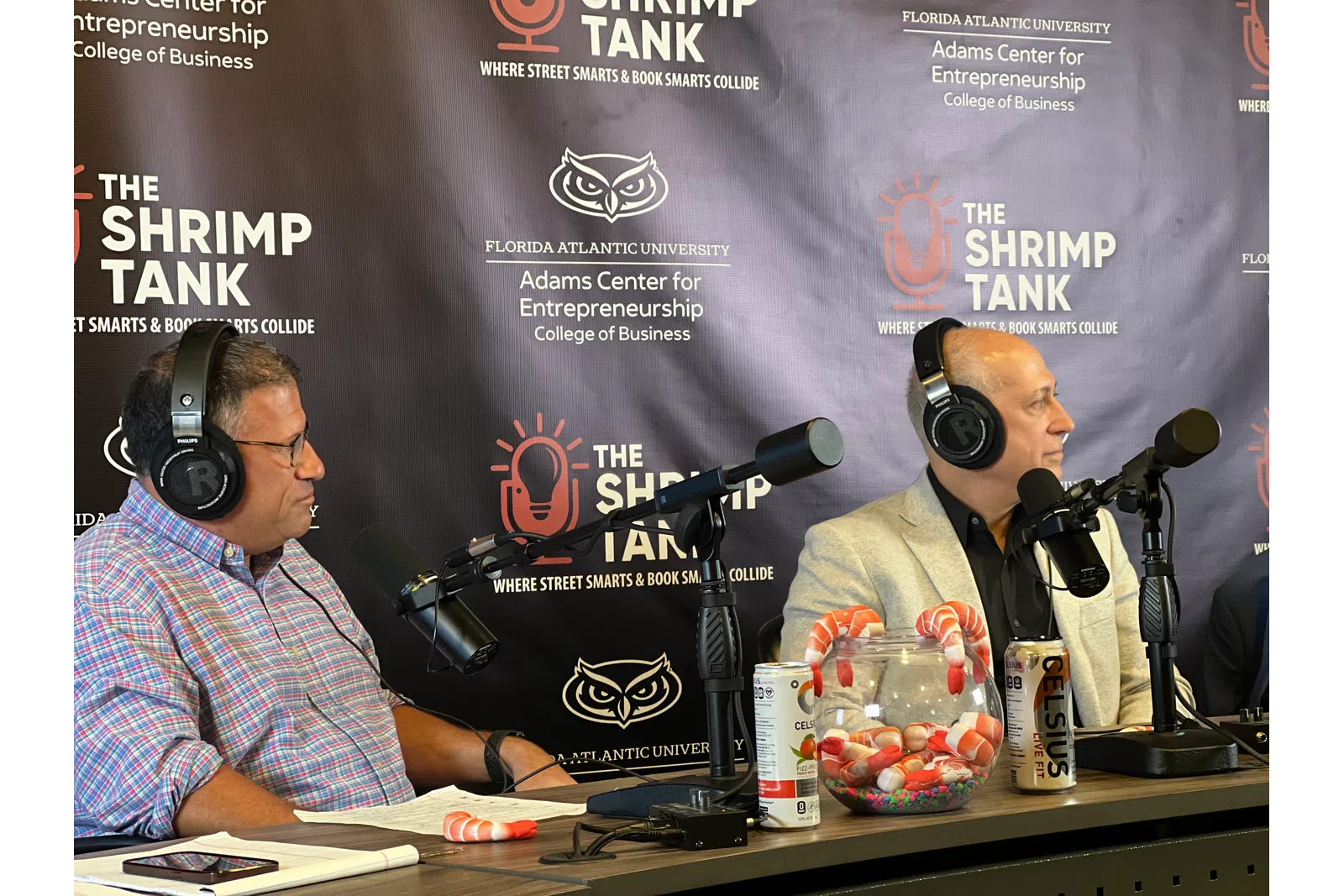Two men wearing headphones speaking into microphones during The Shrimp Tank podcast at Florida Atlantic University.