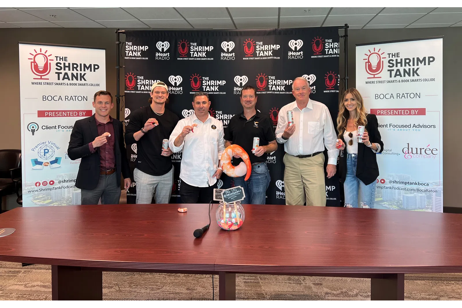 a group of people standing in front of a table with a basketball