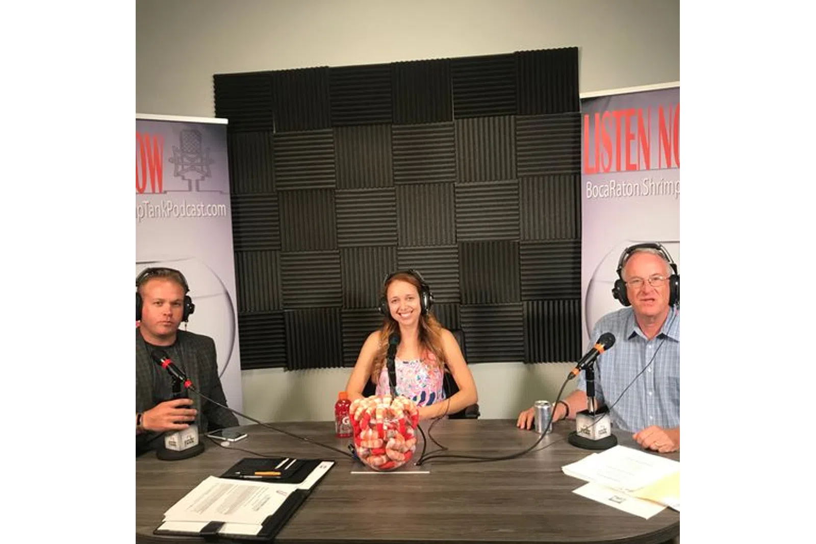 a group of people sitting at a table with microphones