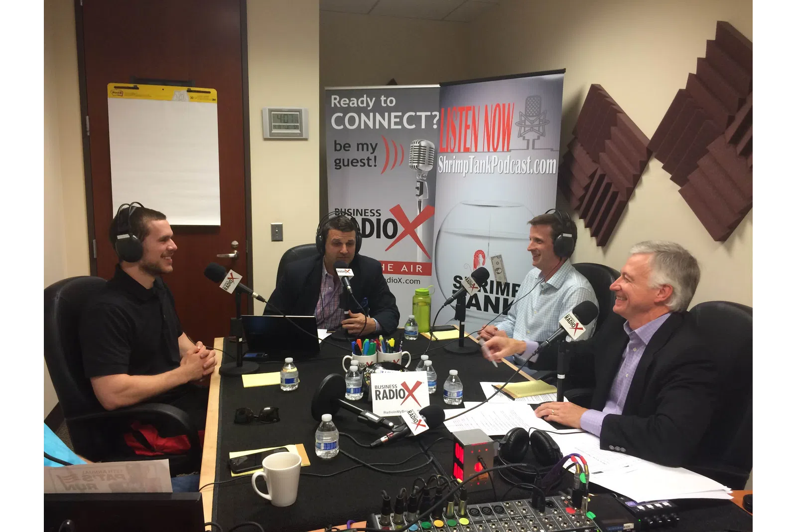 a group of men sitting at a table with microphones