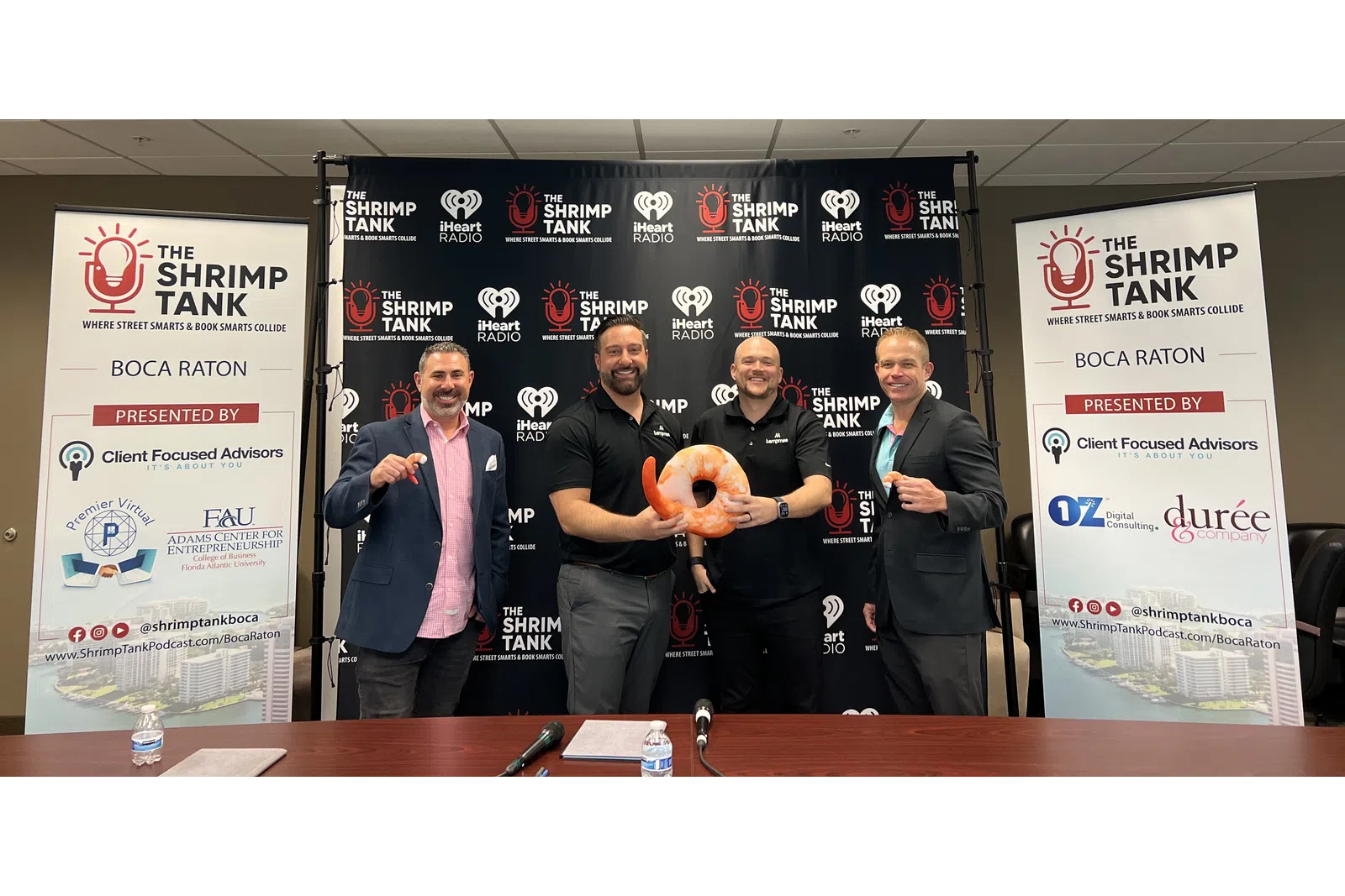 a group of men standing at a podium with a stuffed animal