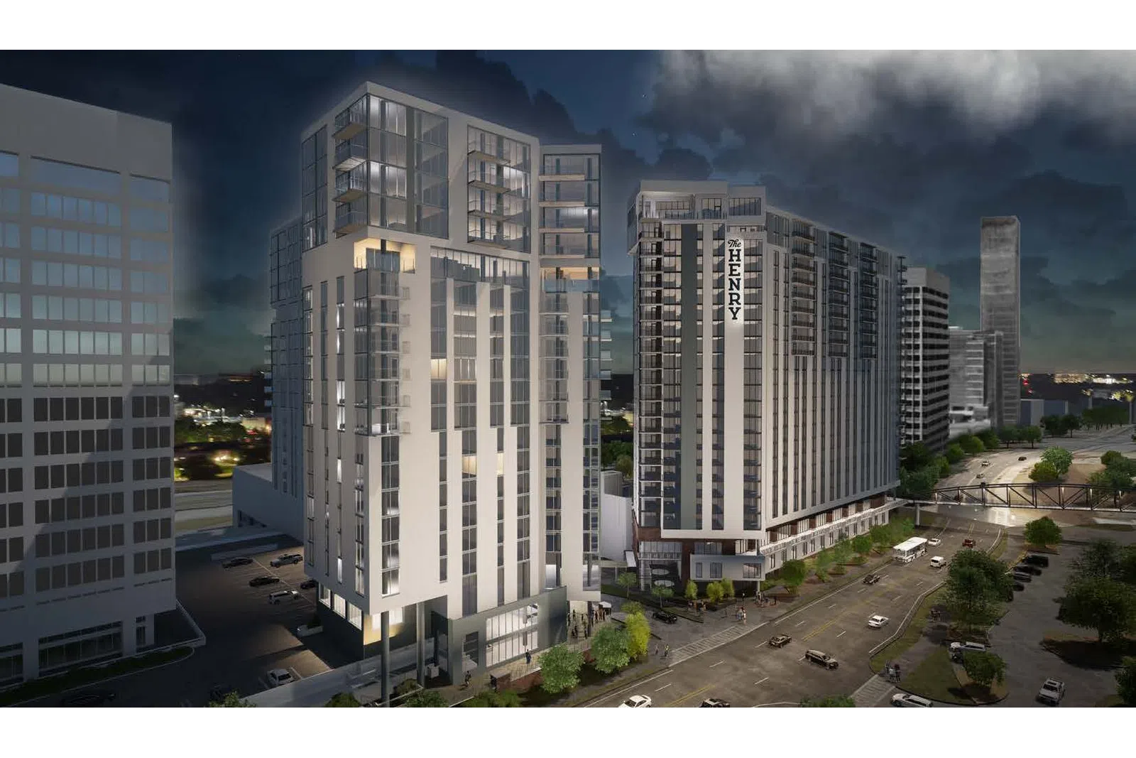 Night view of modern high-rise residential buildings in an urban setting with lit windows and cityscape background