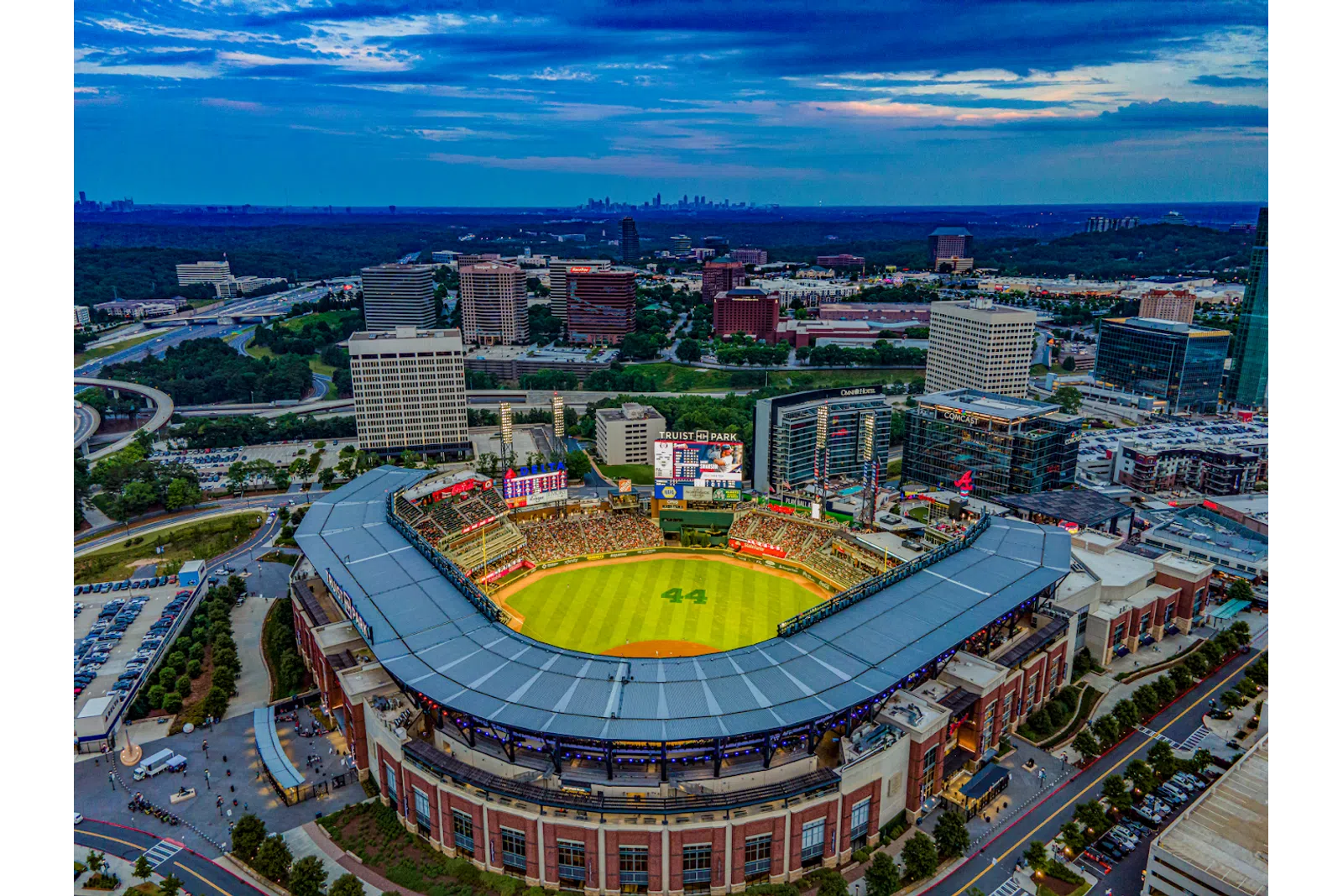 Aerial view of Truist Park baseball stadium with cityscape and cloudy sky at dusk