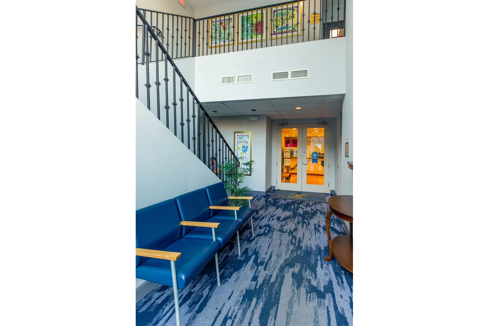 a room with blue chairs and a staircase