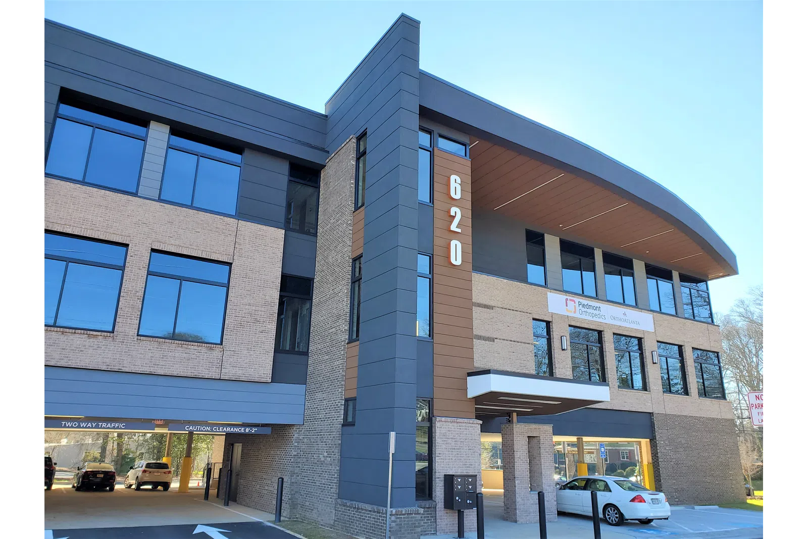 Modern three-story office building with brick and dark panel exterior and large reflective windows at 620 address.