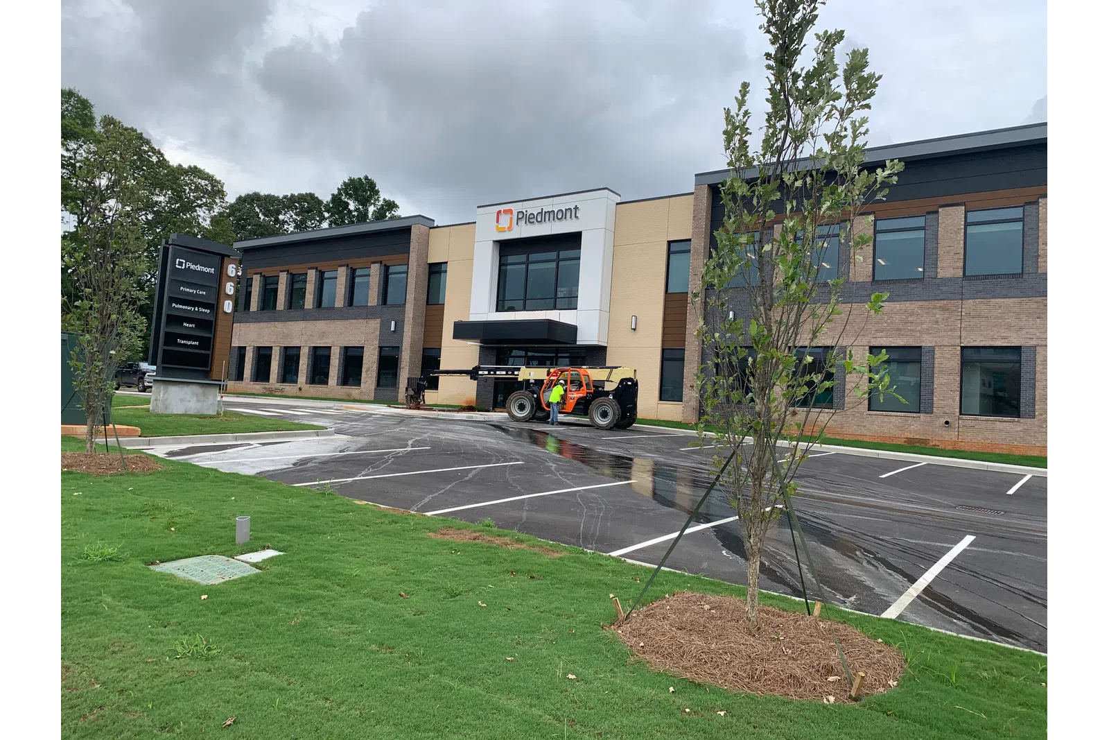 Piedmont medical office building with parking lot, new landscaping, and cloudy sky.