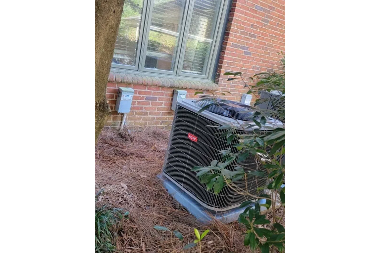 a black garbage can outside a brick building