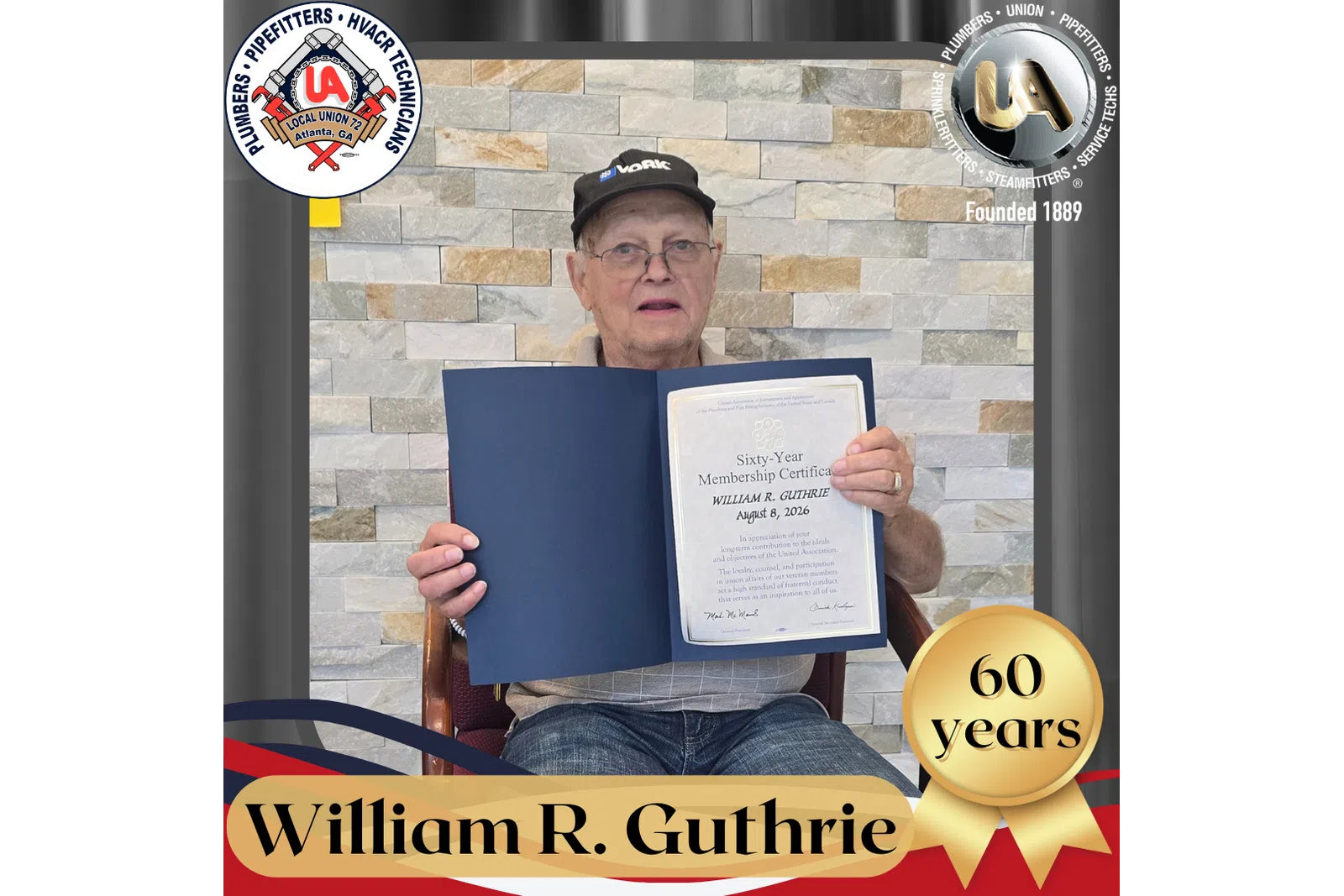 Older man holding a framed sixtieth-year membership certificate seated in front of stone wall background.