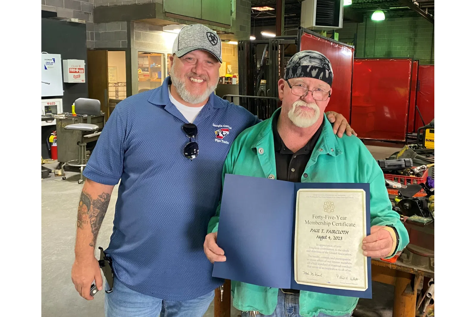 a couple of men holding a certificate