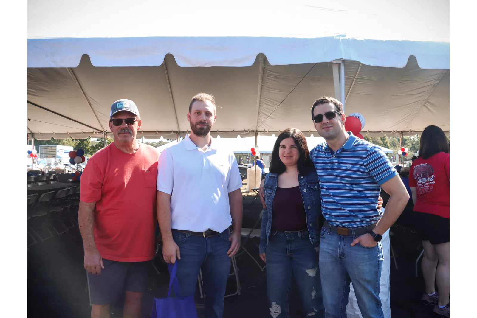 a group of people posing for a photo under a tent