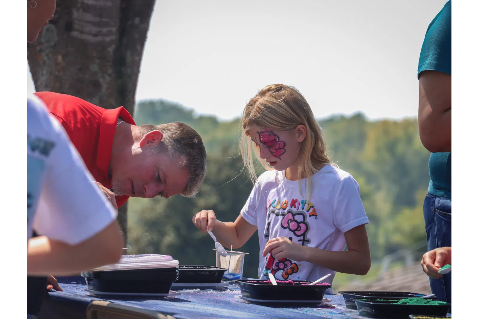 a person and a girl cooking outside