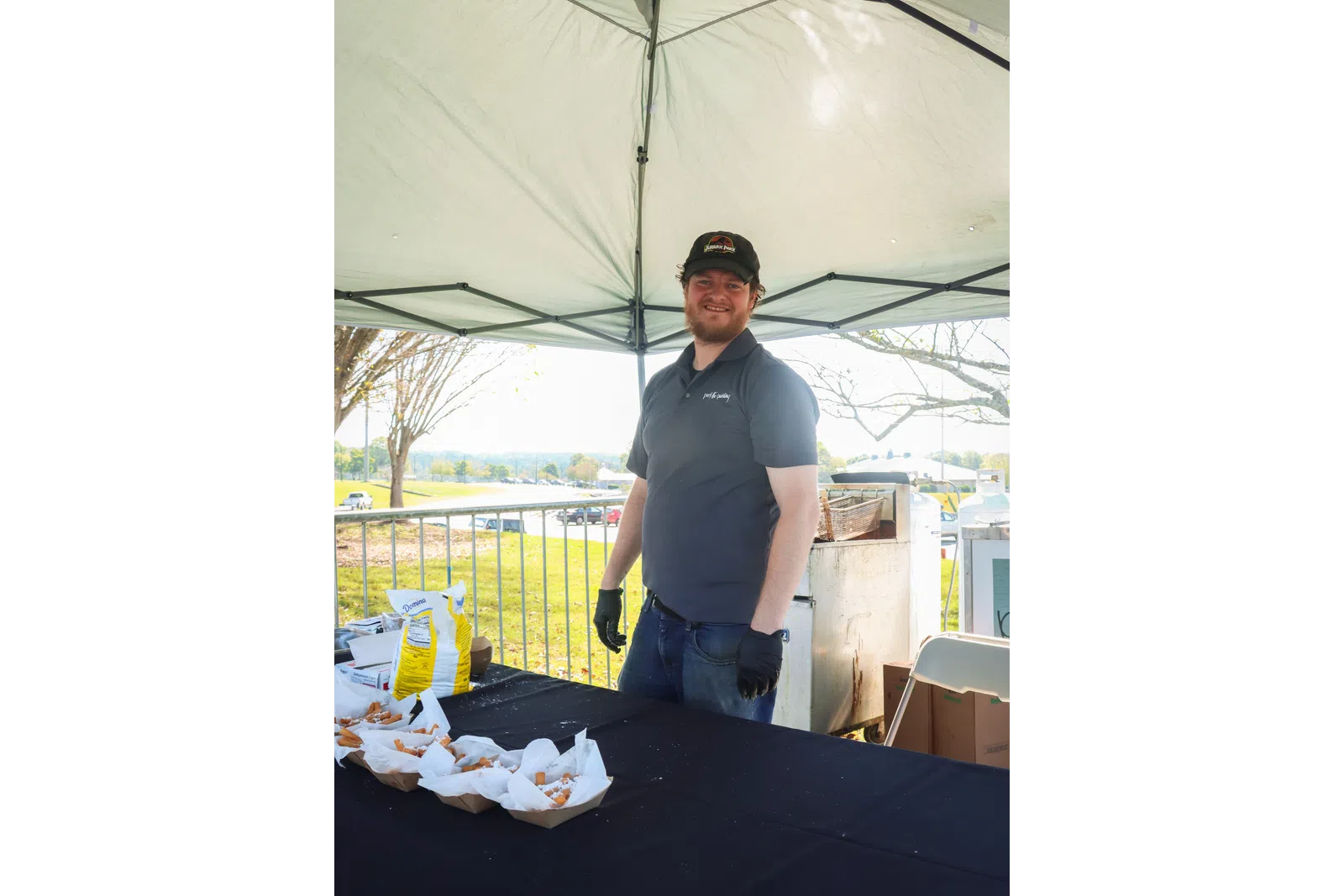 a man standing under a white tent