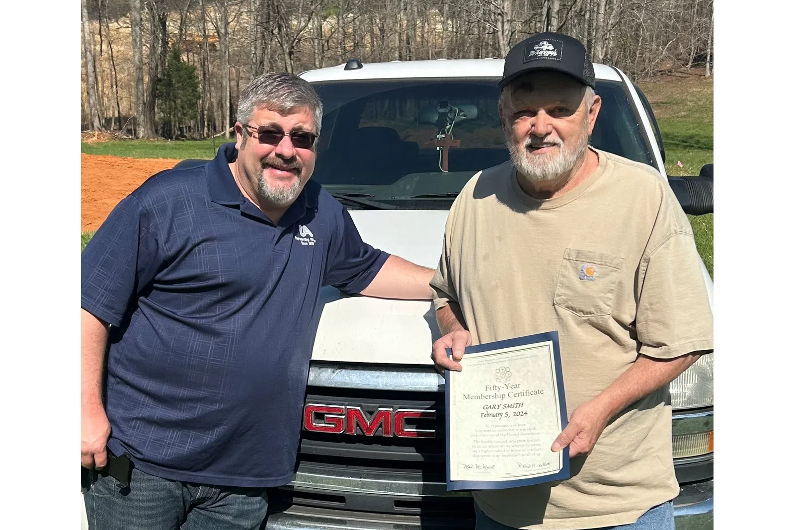 a couple of men holding a certificate