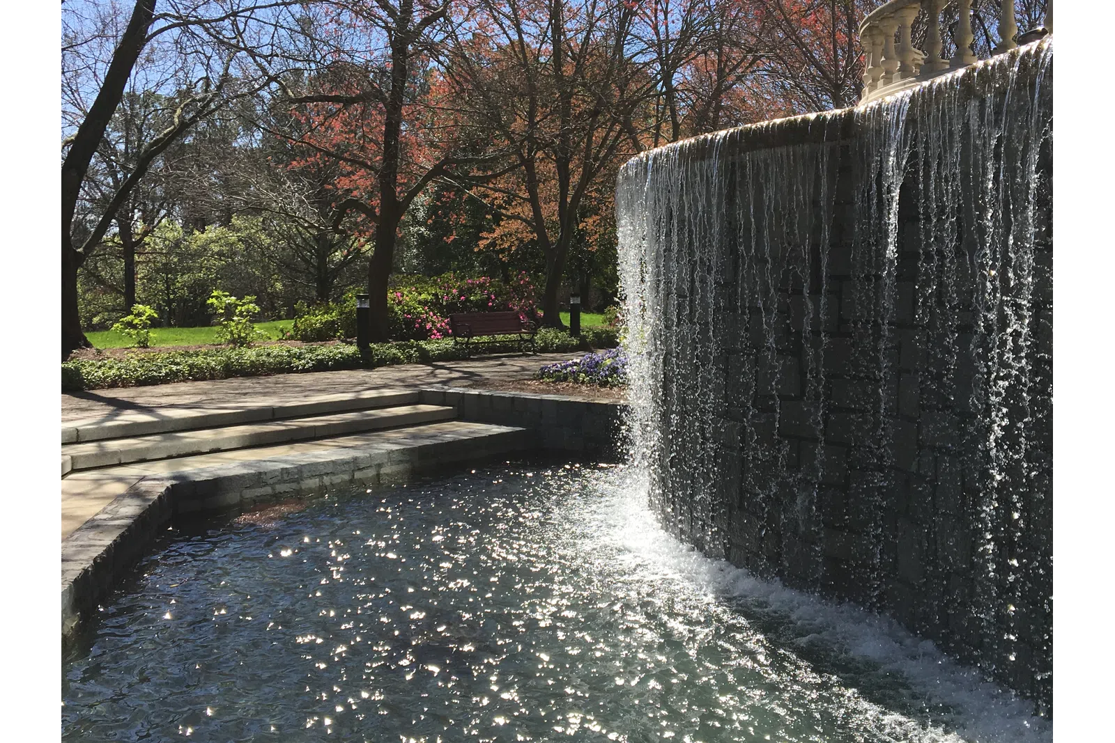 a waterfall with trees and a building in the background