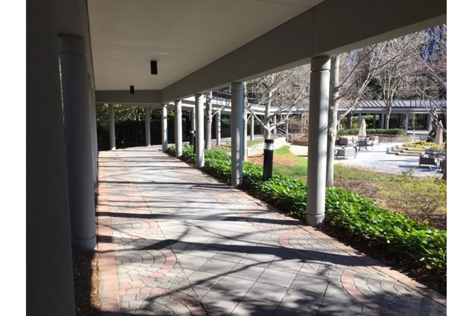a walkway with pillars and grass