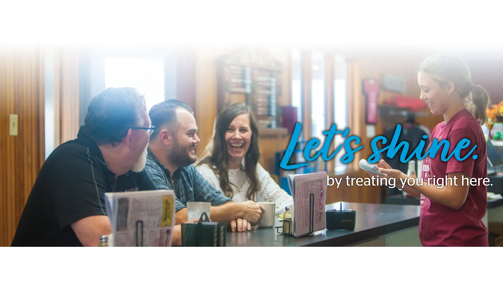 People sitting at restaurant smiling at server