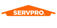 SERVPRO West Chelmsford logo with orange house shape and bold black and white text on black background