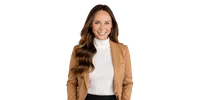 Smiling woman with long wavy hair wearing a white turtleneck and camel blazer, isolated on transparent background