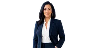 Confident businesswoman with black hair in navy blazer and white blouse posing with hand in pocket