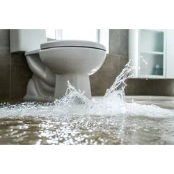 Water flooding and splashing on bathroom floor near toilet showing you need an emergency plumber near you