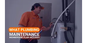 Estes Services Plumber  in orange shirt inspecting a water heater for plumbing maintenance membership plan services.