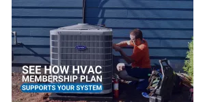 Estes Services Technician in orange shirt performing maintenance on outdoor HVAC unit beside blue house siding and gardening tools.