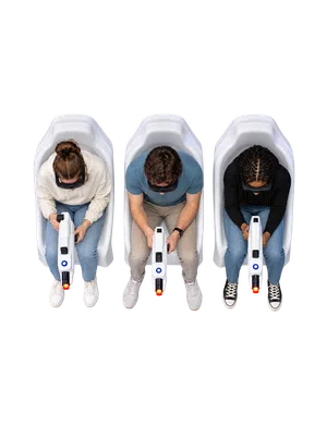 Three individuals wearing VR headsets seated in white pods holding white gaming guns with glowing red tips, viewed from above.
