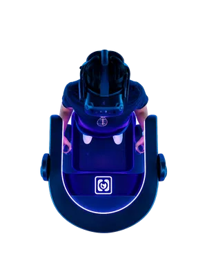 Top view of person using VR headset and controllers inside illuminated futuristic gaming pod with neon lights.
