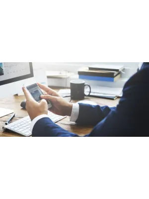 a man using a laptop computer sitting on top of a table