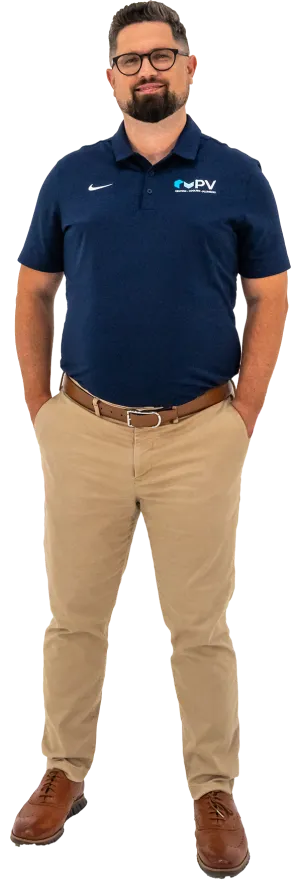 Man wearing navy blue PV Heating Cooling Plumbing polo and khaki pants with brown shoes and glasses
