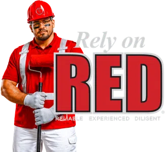 Worker in red uniform and helmet holding a paint roller with text Rely on RED for reliability and diligence.