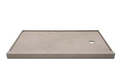 Rectangular concrete shower base with raised edges and circular drain hole on white background