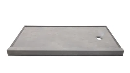 Rectangular gray stone shower base with raised edges and a circular drain hole on one side.