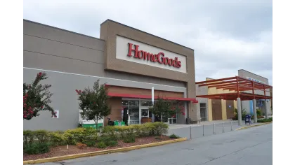 Exterior view of a HomeGoods store with clear signage and landscaped entrance under a cloudy sky.