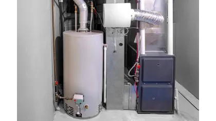 Modern water heater and furnace system installed in a clean basement utility room with pipes and ducts