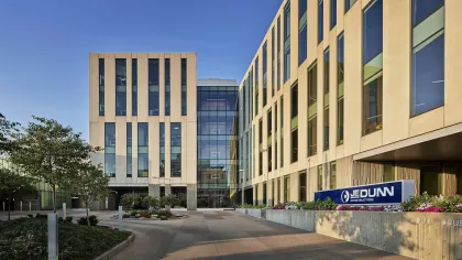 Modern commercial building exterior with glass windows and Jedunn Construction sign at entrance.