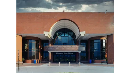 Entrance to Johnson County Community College Midwest Trust Center with large arched windows and brick facade under cloudy sky