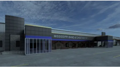 Modern building of Mississippi Band of Choctaw Indians under a cloudy sky with large windows and paved parking area.