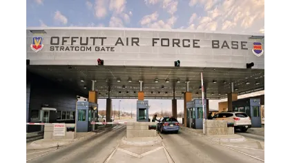 Entrance gate of Offutt Air Force Base Stratcom Gate with vehicles and guard booths under a clear sky.